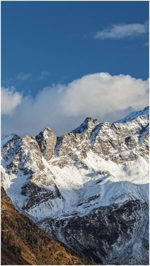 Snow-covered mountain peaks under a blue sky in Ma