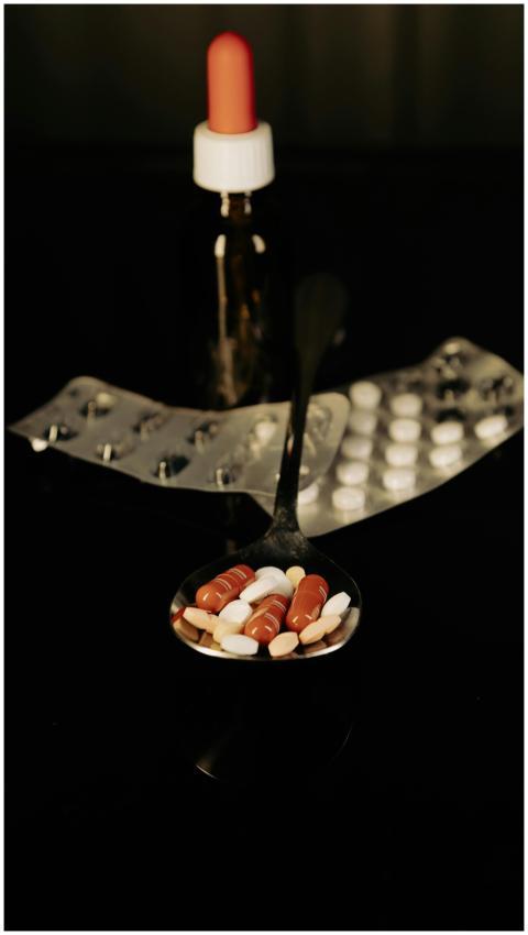 Close-up of assorted pills on a spoon with blister