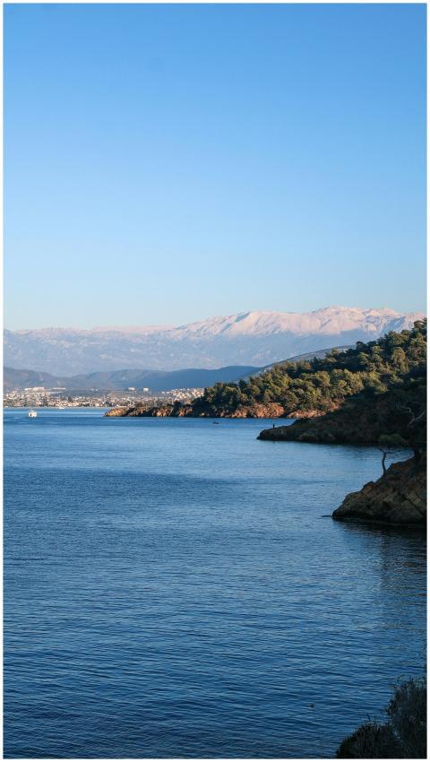 Serene coastal landscape with mountains under clea