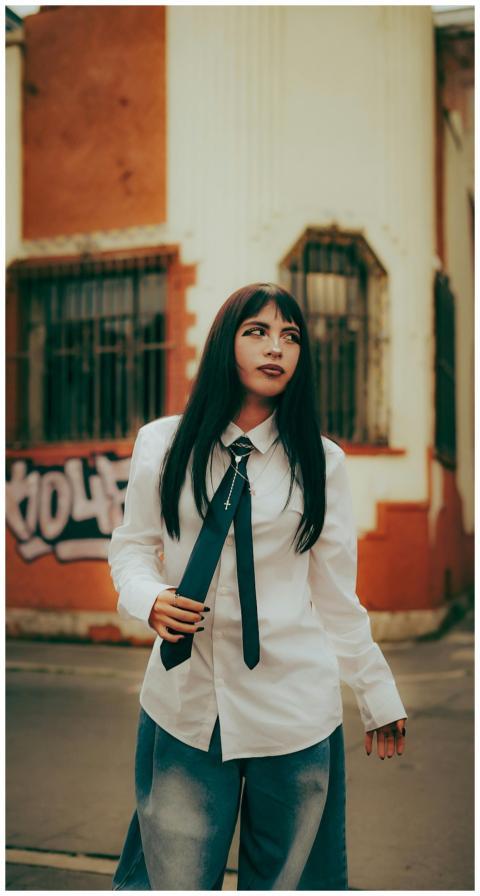 Young woman in stylish outfit posing in city stree