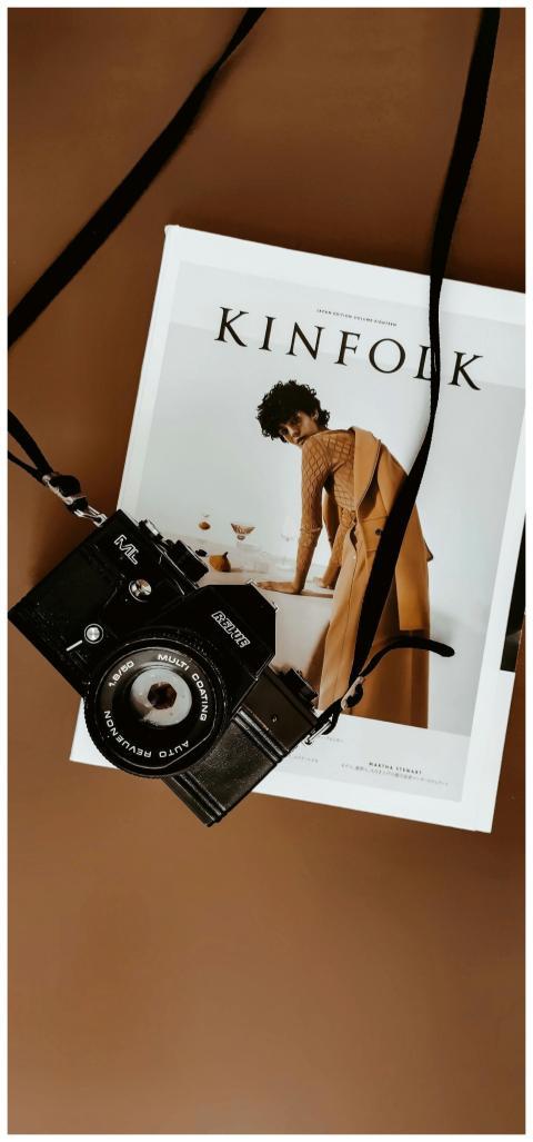 A vintage camera lays on a Kinfolk magazine agains