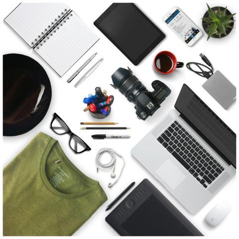 Top view of a creative workspace with camera, lapt