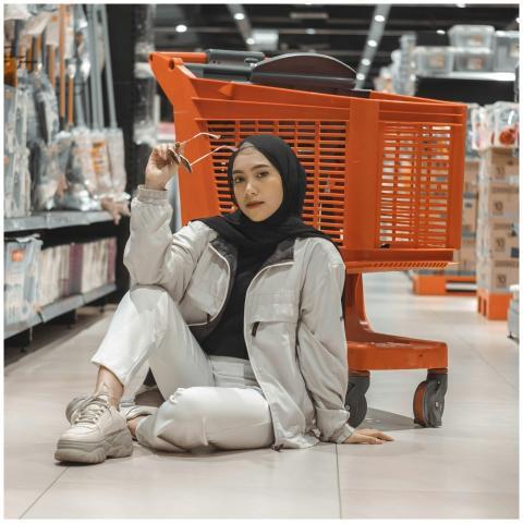 Stylish young Muslim woman sitting in a supermarke
