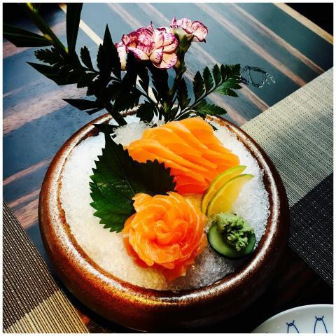 A beautifully presented salmon sashimi dish with f
