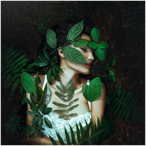 Serene portrait of a woman lying amidst vibrant gr