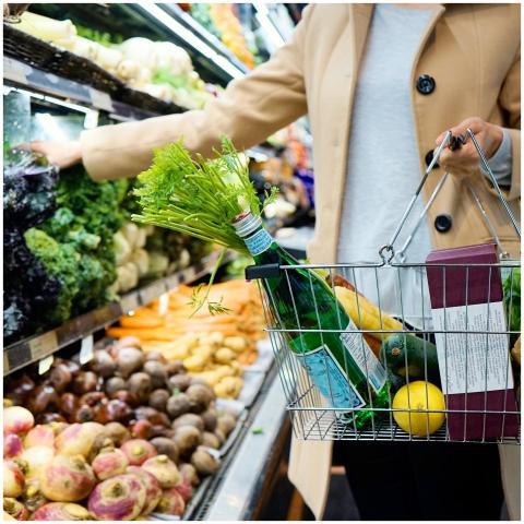 Woman selecting fresh produce in a supermarket wit