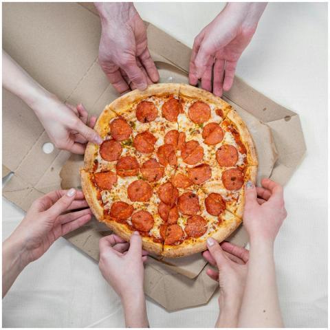 A group of friends enjoying a pepperoni pizza, sha
