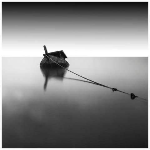 A moored sunken boat in still water captured in mo
