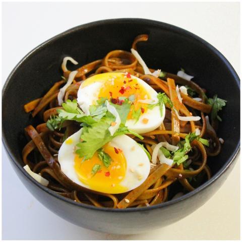 A savory bowl of egg-topped noodles garnished with