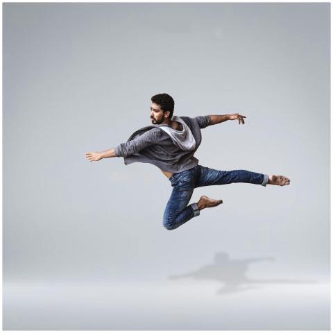 A male contemporary dancer in casual wear leaping