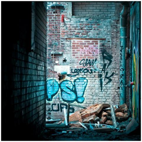 Abandoned alley showcasing vibrant graffiti on a d