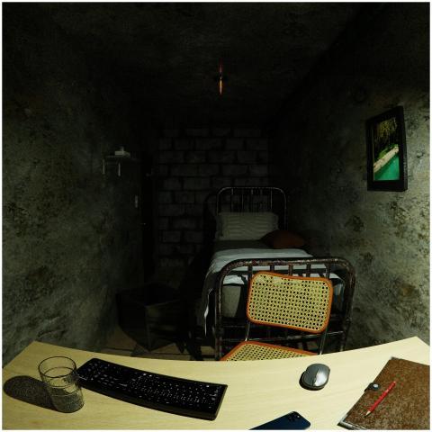 A dimly lit basement room with a computer setup an