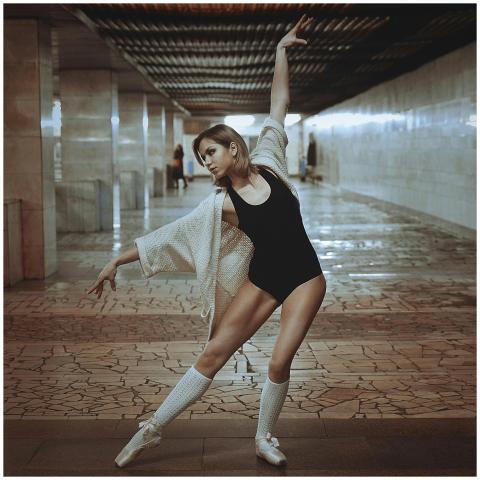 A graceful ballerina poses in a dramatic urban cor