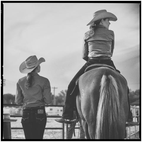 Women in cowboy hats enjoying a serene moment, one