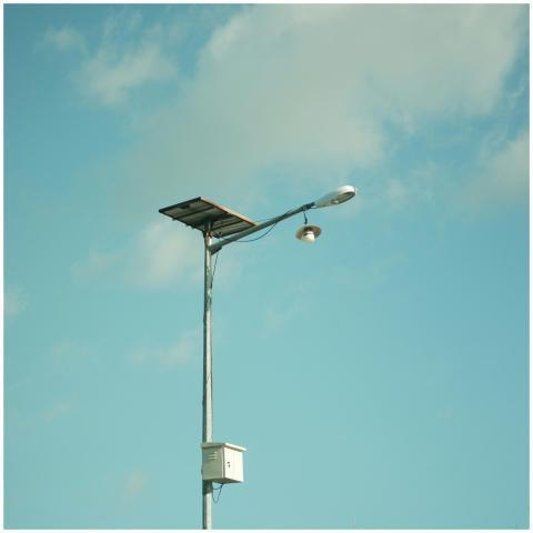 A solar-powered street light set against a clear,