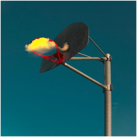A surreal image of a basketball hoop with a cloud