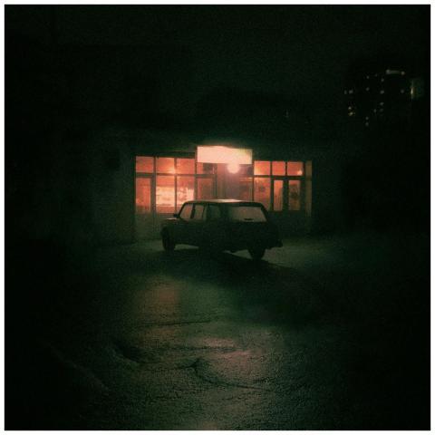 Moody night scene with a retro car in front of an