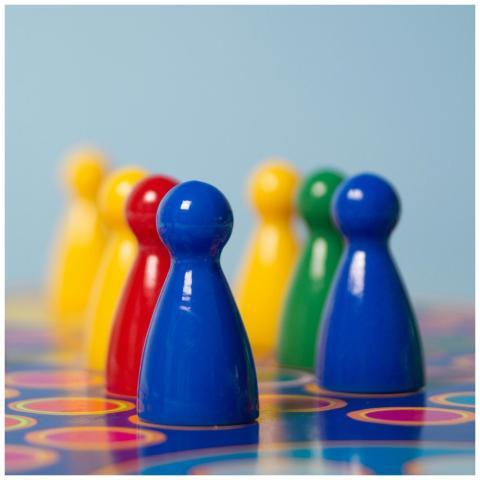 Vivid colored board game pawns arranged on a decor