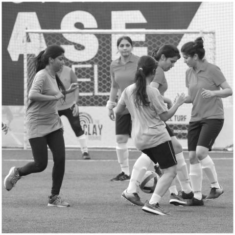 Women playing soccer on an outdoor field, capturin