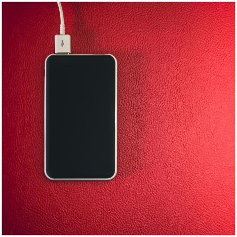 A smartphone connected to a charger placed on a re