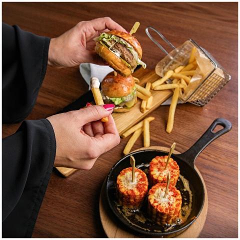 Delicious burger meal with fries and corn skewers