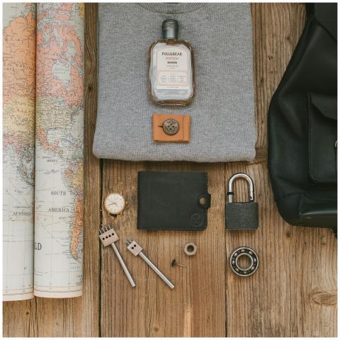 Flat lay of travel items including a map, wallet,
