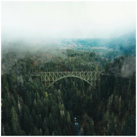 Stunning aerial shot of a bridge spanning a misty