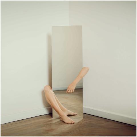 Surreal photo featuring a mirror reflecting an arm