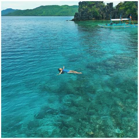 Relaxing scene of a woman floating in clear turquo