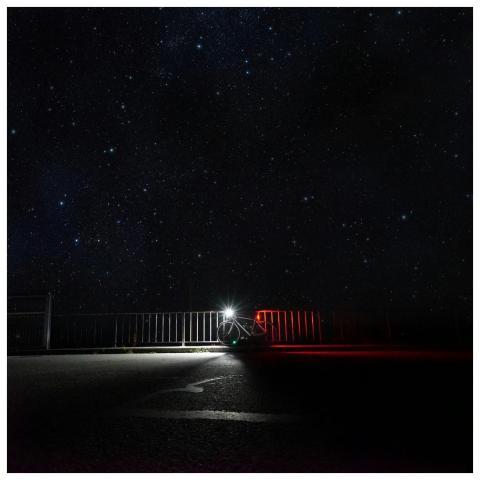 A quiet road scene with a bicycle under a vast sta