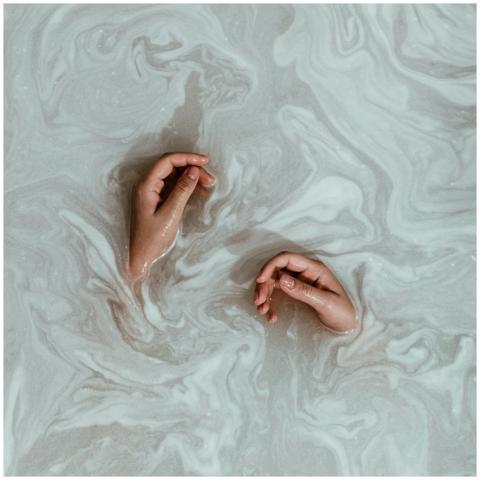 Artistic photo of hands floating in swirling water