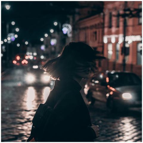 Silhouette of a woman walking on a bustling city s