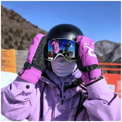 A person dressed for skiing or snowboarding in win