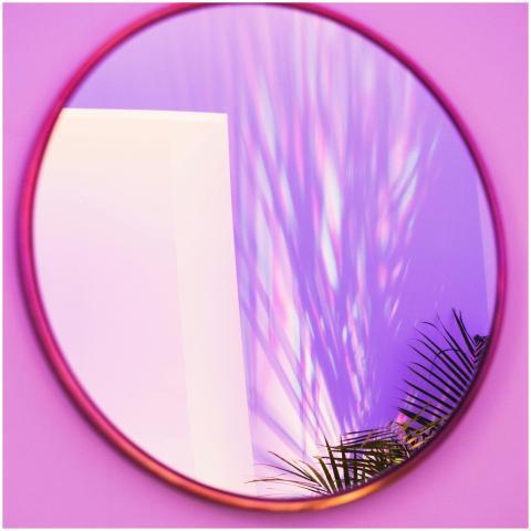 Round mirror reflecting colorful light patterns an