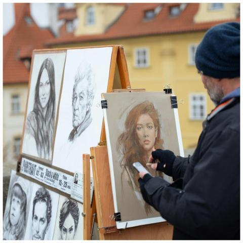 Street artist creating portraits on an easel in an