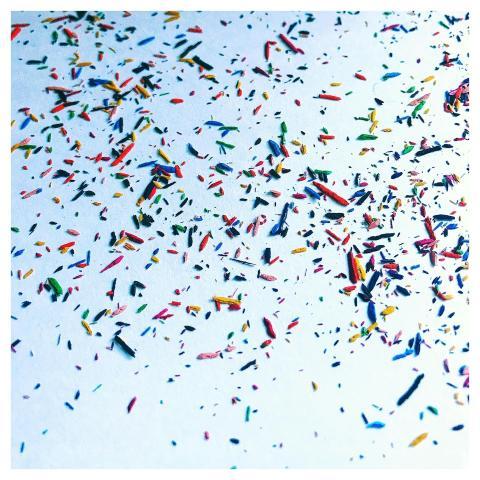 Vibrant multi-colored confetti scattered on a whit