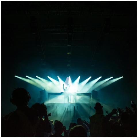 DJ electrifying the club with vibrant lights and e