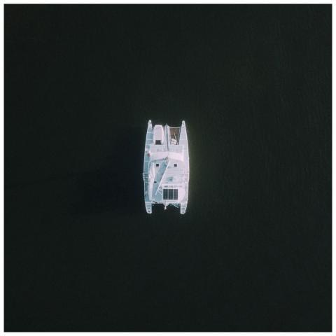 Top-down aerial shot of a catamaran sailing on cal