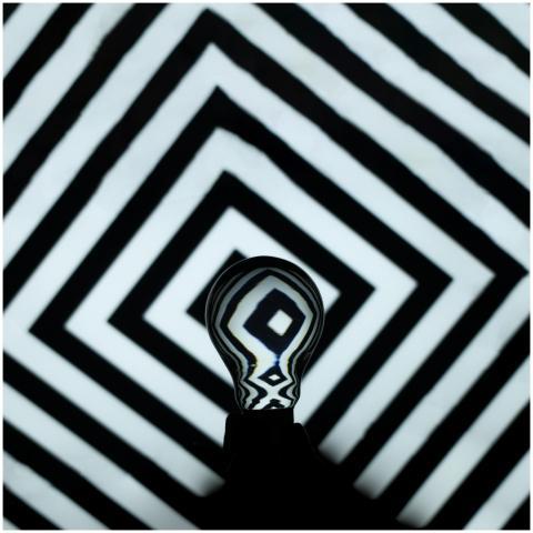 Creative photo of a light bulb against a hypnotic