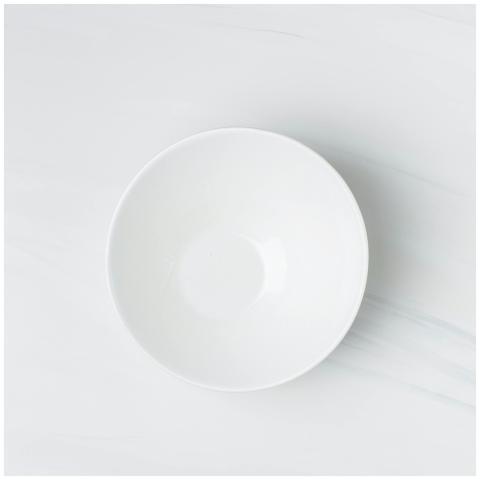 Top view of a white ceramic plate on a marble surf