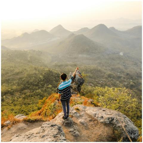 Man pointing at scenic Mandau Talawang mountains,