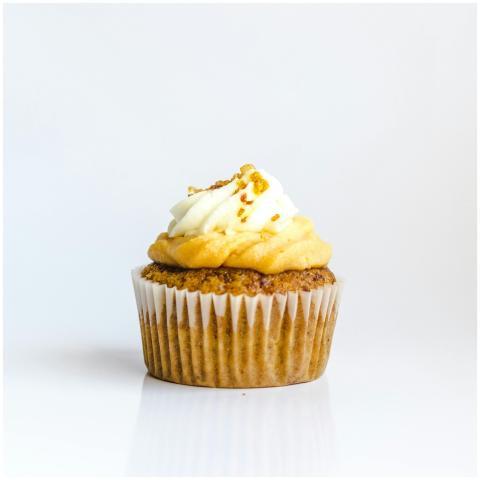 A delectable cupcake with creamy frosting on a whi