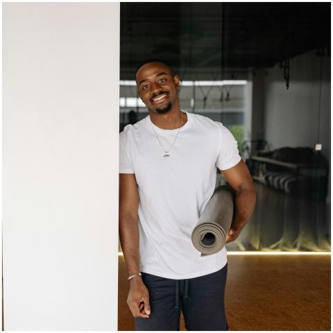Young man in a white shirt smiling and holding a y