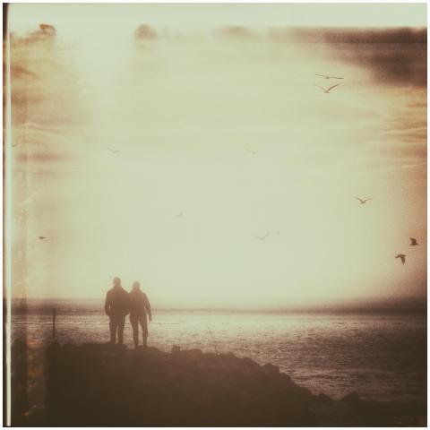 A romantic vintage photo of a couple walking at su