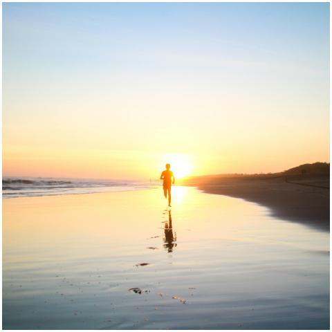 A lone silhouette of a person running along a sere