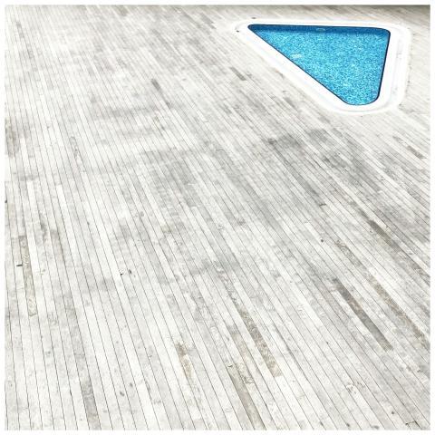 Aerial view of a minimalist wooden deck with a blu