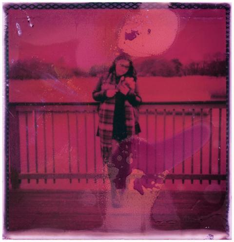 Artistic pink-tinted photo of person standing by a