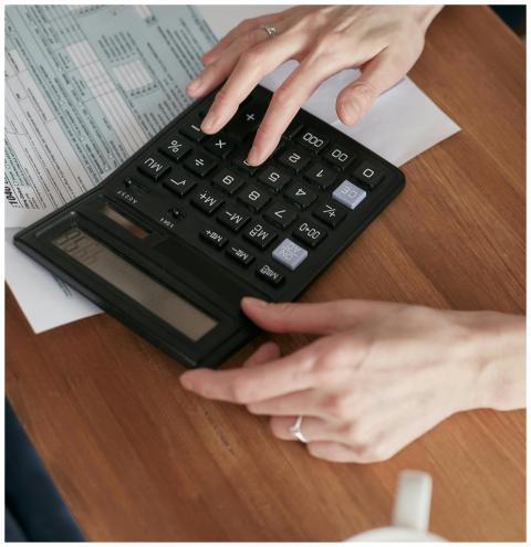Person calculating finances with a calculator and