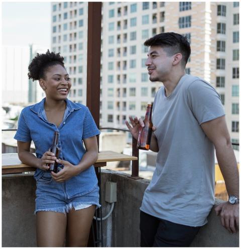 Two young adults enjoying drinks and conversation